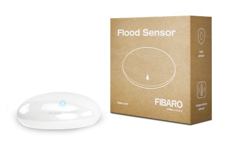 Bílý a kulatý záplavový senzor Fibaro leží na bílém pozadí s krabičkou.